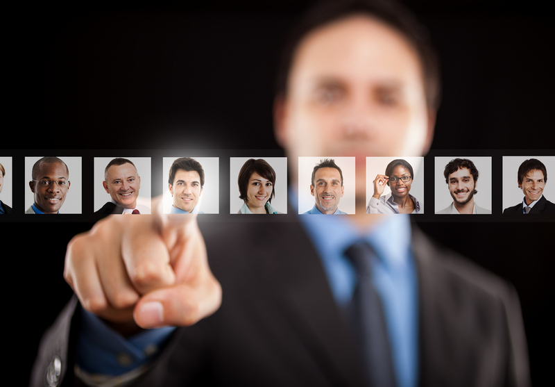 A man pointing forward with a row of candidate portraits floating in front of him.