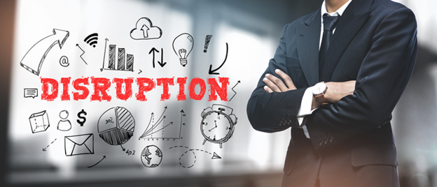 A businessman with arms crossed beside the word Disruption surrounded by business icons.
