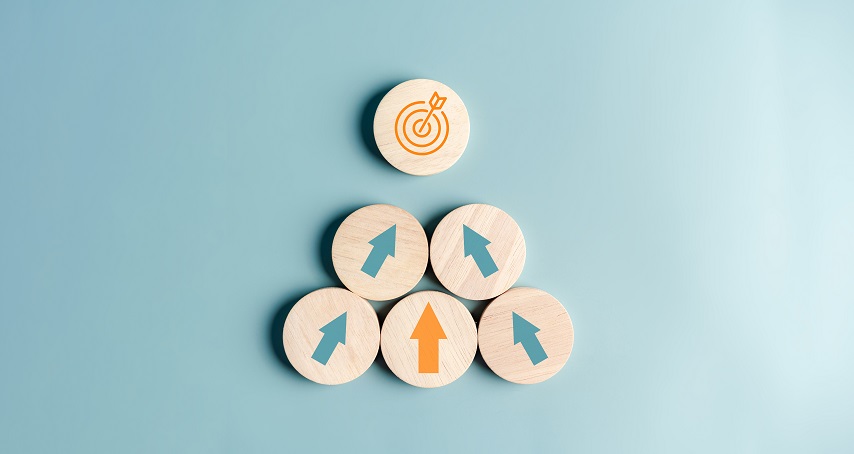 Wooden discs with arrows pointing in different directions beneath a target icon.