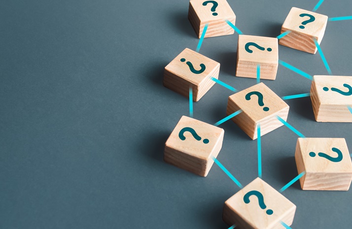 Wooden blocks marked with question marks connected by lines on a dark surface.