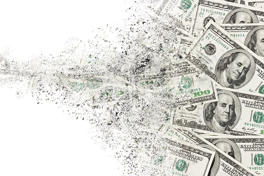 Hundred dollar bills dissolving into scattered particles.