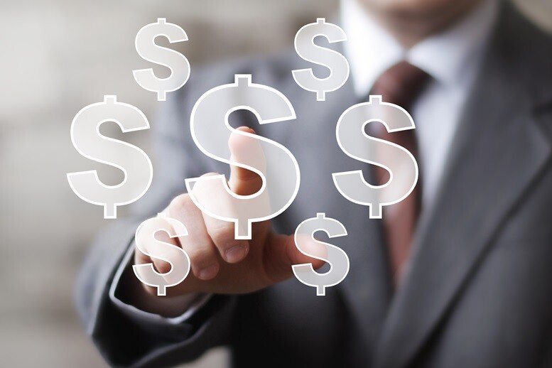 A businessman touching one of several floating dollar sign icons.