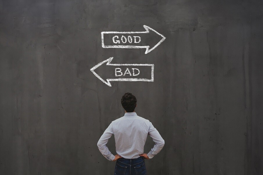 A man standing before a chalkboard with arrows pointing toward Good and Bad.