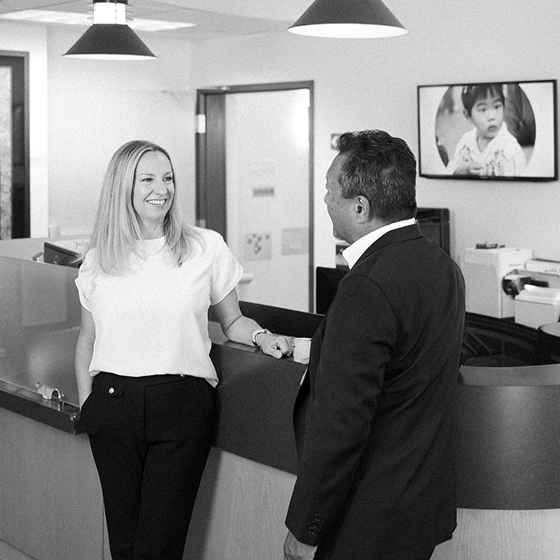 Becky Todd of CFO Selections talking with Gary Yamamoto in the Kindering reception area.