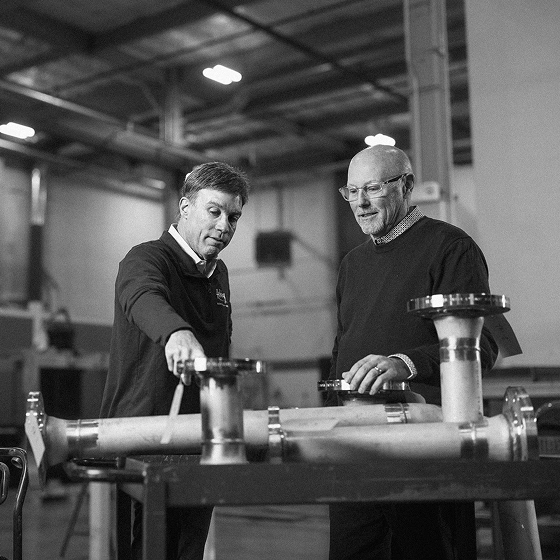 Kevin Briscoe of CFO Selections and Jeff White of Holmberg Mechanical inspecting a pipe assembly in the shop.