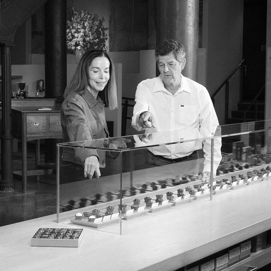 Kurt Maass of CFO Selections and Andrina Bigelow of Fran's Chocolates looking over a chocolate display case.