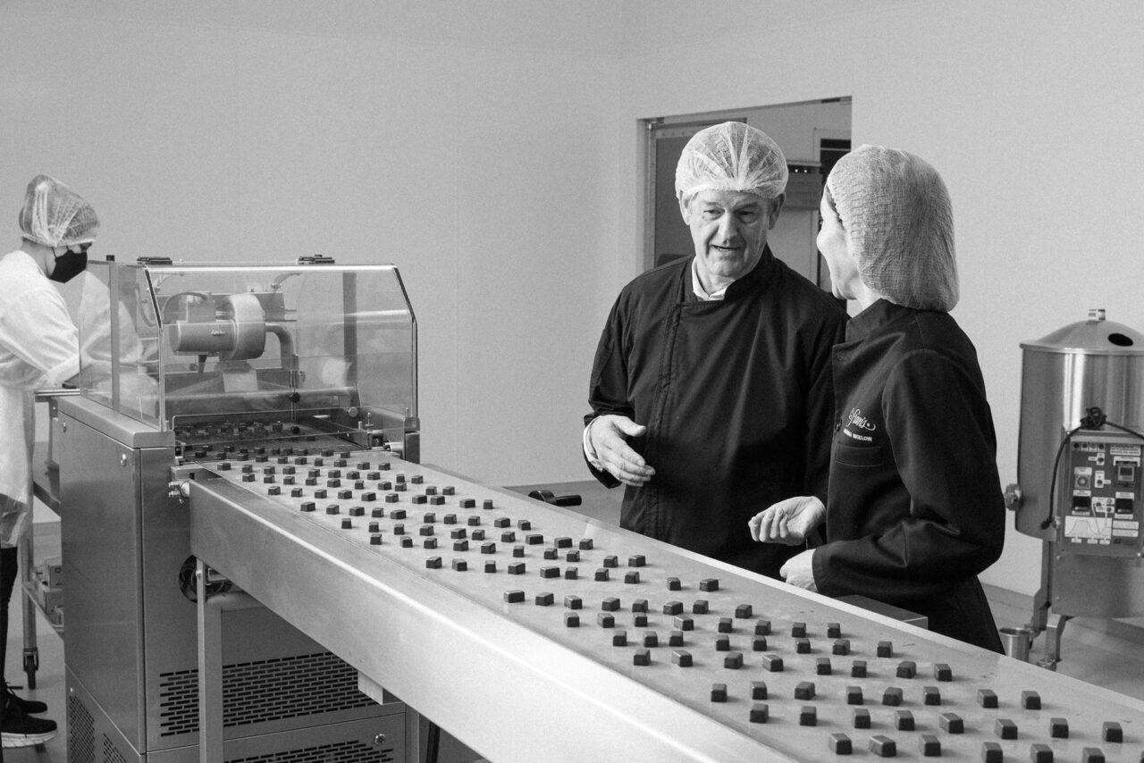 Fractional CFO Kurt Maass and CEO Andrina Bigelow watching the Fran's Chocolates production line
