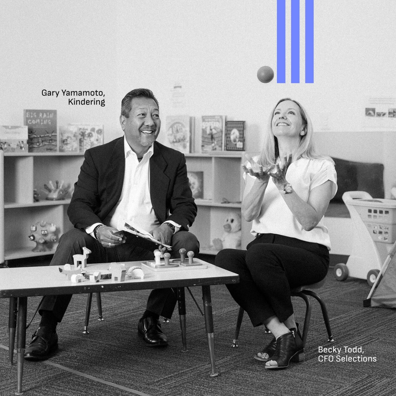 Becky Todd of CFO Selections and Gary Yamamoto of Kindering seated in a Kindering classroom as Becky tosses a ball in the air