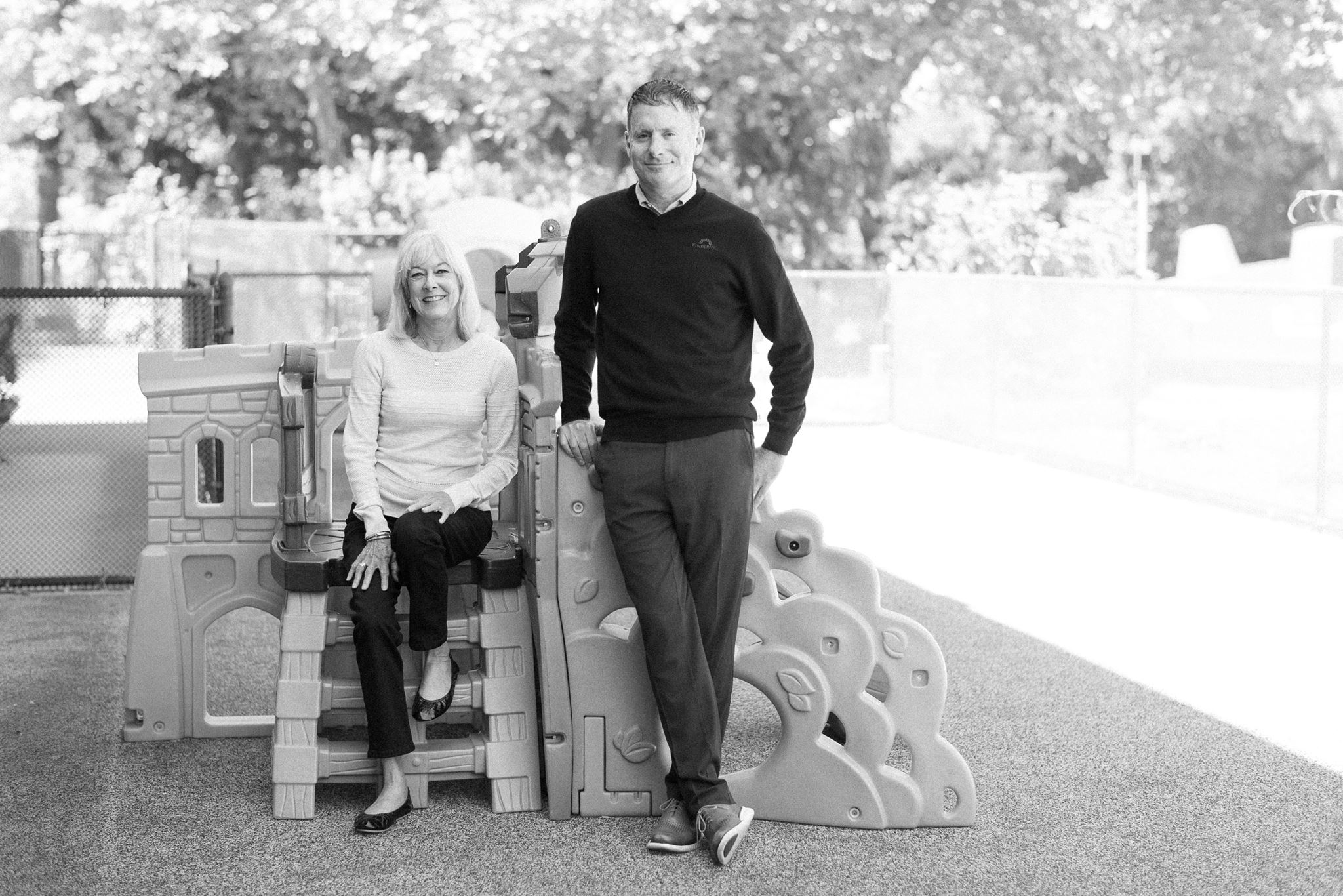 Fractional CFO Mari Offenbecher and Kindering CEO Mike Stewart by children's play equipment